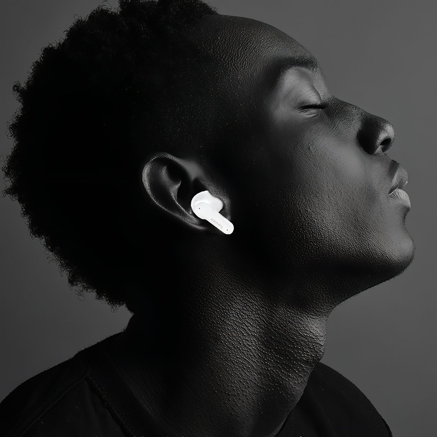 Person wearing Keovy Translator Earbuds with a dark background