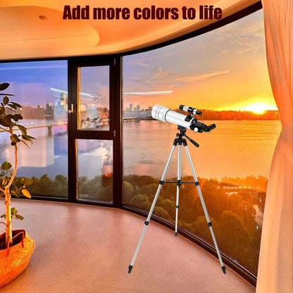Astrogazeir Telescopes on a tripod in a room with a large window view of a sunset.