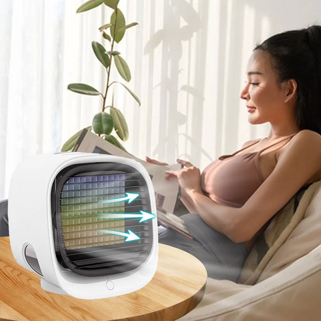 Woman reading a newspaper next to a small Coolevax Portable Air Conditioner in a bright room.