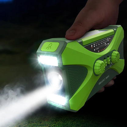 Green CrisyCom emergency radio with flashlight held by a hand in a dark setting