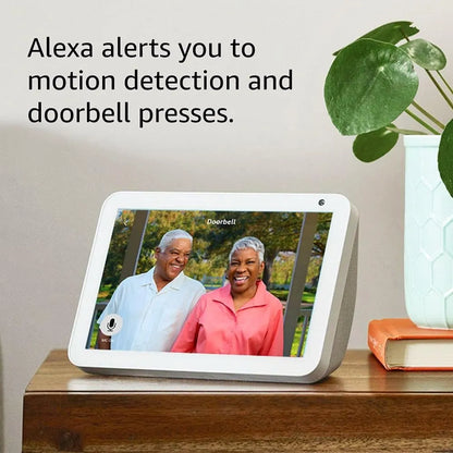 Smart display device showing an elderly couple on a screen with text about Alexa alerts.