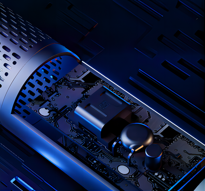 Close-up of a dark electronic circuit board component under dramatic blue lighting, showing a rectangular processor chip, cylindrical connectors, and printed circuitry inside a metallic housing.