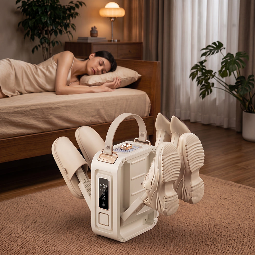 A white and beige automatic shoe Elarvo Shoe & Boot Dryer with a digital display is shown drying several pairs of white slippers and shoes. In the background, a woman is sleeping peacefully on a wooden bed in a cozy, warmly lit bedroom.