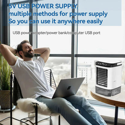 Person using a laptop with a portable air conditioner in a modern room.