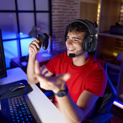 Man in a red shirt playing video games with a Ironis Wireless Gaming Headset and controller in a room with gaming setup.