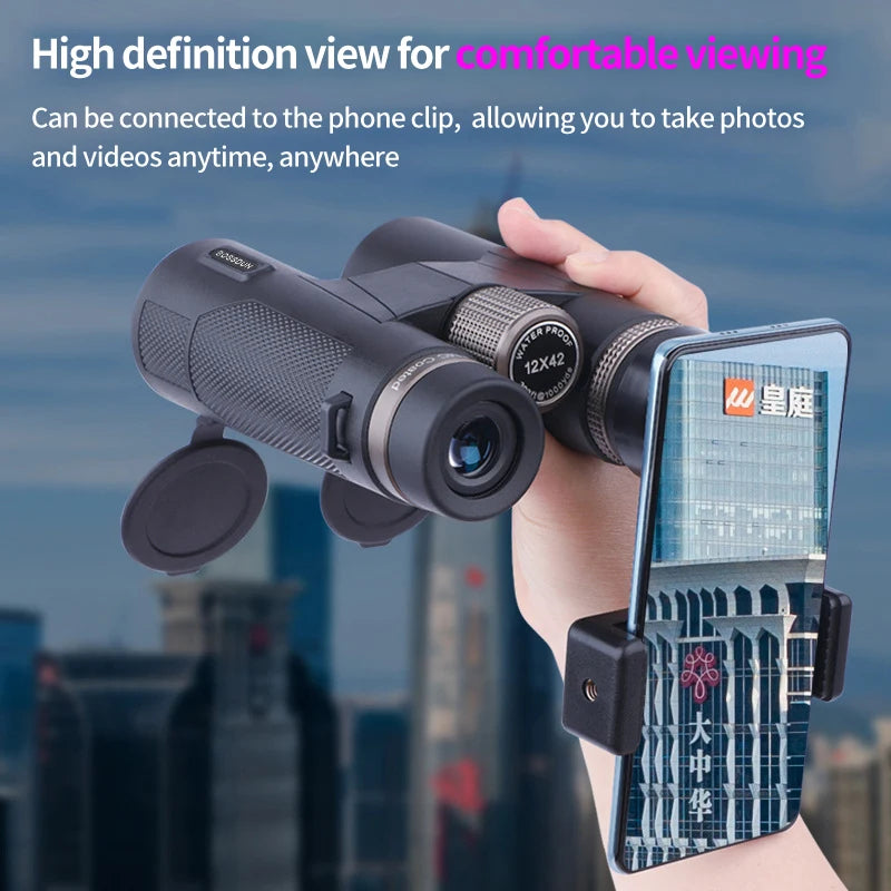 Hand holding Kaisio Sky X7 ED 12×50 Binoculars with a phone clip attached, cityscape in the background