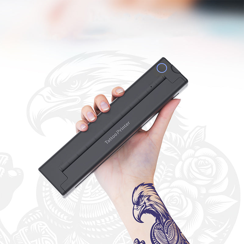 Hand holding a Keovy Tattoo Printer with a tattoo on a blurred background