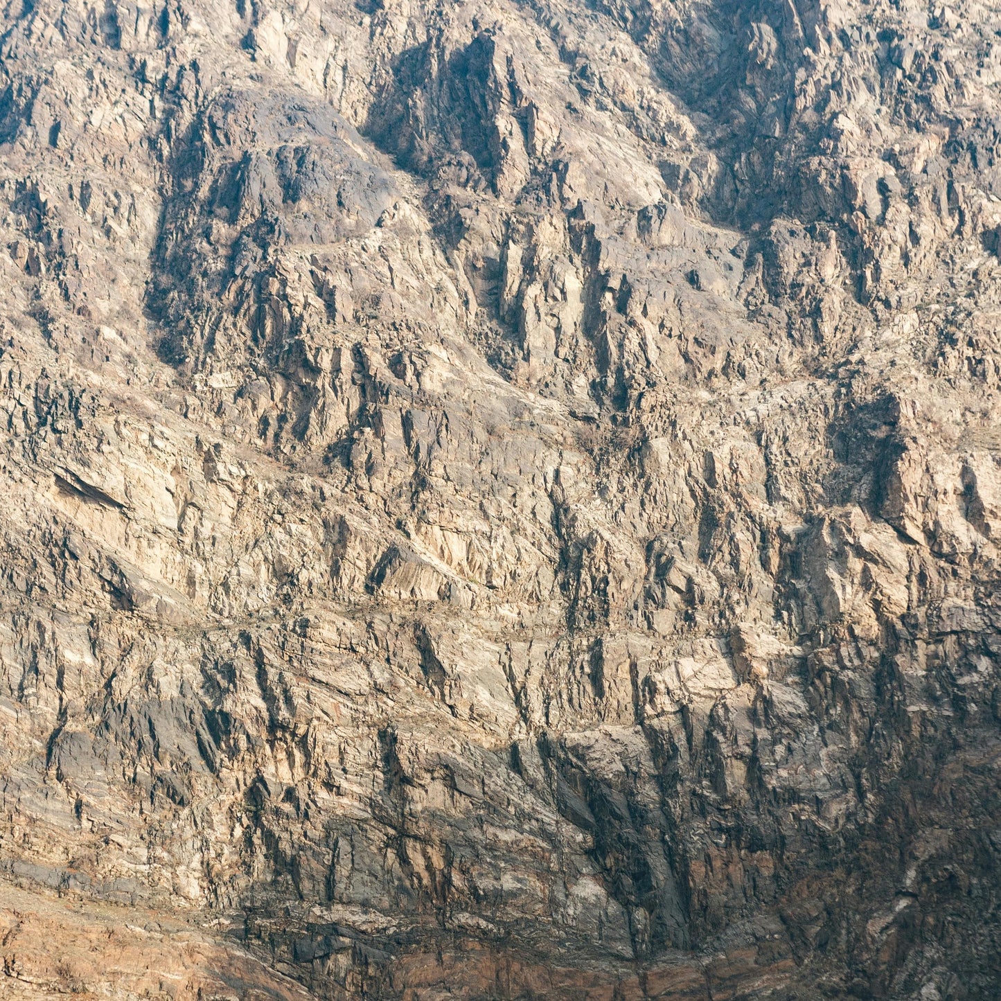 Rough, textured surface resembling a mountain or rock wall.