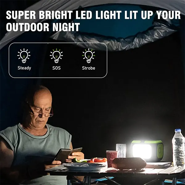 Person using a smartphone at a table with a bright light source in the dark, highlighting LED light features MQPower Portable Power Stations