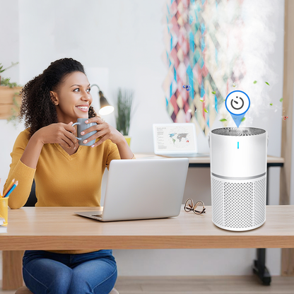 Woman sitting at a desk with a laptop and Mivrass Air Purifier, holding a mug.