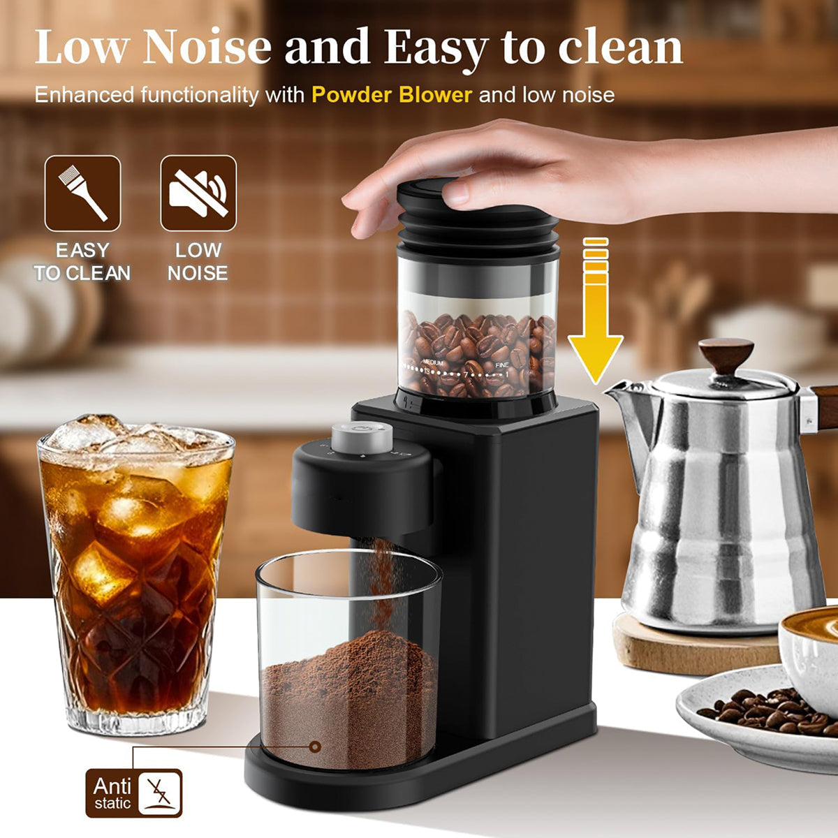 A black countertop NeadGrint Espresso Grinder shown in a kitchen-like setting with a hand pressing the top lid. The grinder dispenses coffee powder into a clear glass, with an iced coffee glass, a stainless steel moka pot, and coffee beans visible.
