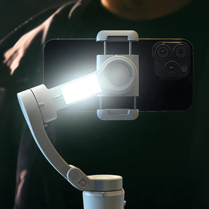 Smartphone with a mounted light and Optego Gimbal on a dark background