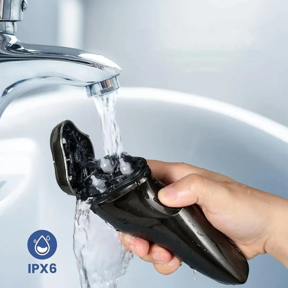 Hand holding a black Oreliom ProCut Electric Shaver under running water from a faucet, with IPX6 rating logo.