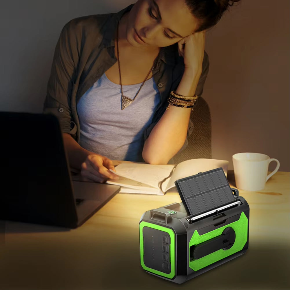 Woman studying at a desk with a green and black portable device on a table.
