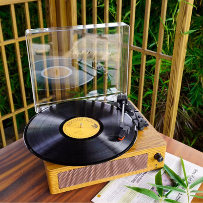Wooden RetroSiDy Record Player with a vinyl record on a table outdoors.