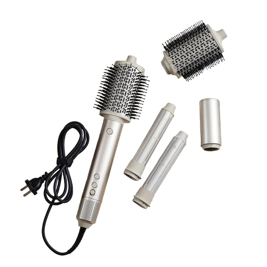 A SaharaCurl RQ30 Automatic 5-in-1 Hot Air Styler styling tool set laid out on a beige carpet with its power cord, two interchangeable brush barrels, and a black carrying case nearby. A magazine and sunglasses are also visible as styled props.