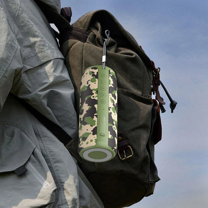 Camouflage-patterned portable speaker attached to a backpack with a clear sky background