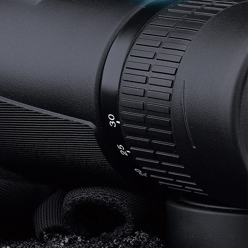 Close-up of a black rifle scope with focus ring details