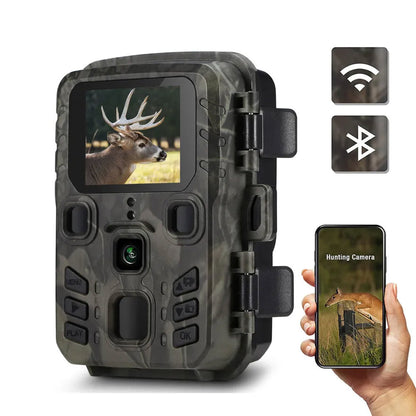 Camouflage TrackaPix Wildlife Camera with screen displaying a deer image, held by a hand with a smartphone showing the same image.