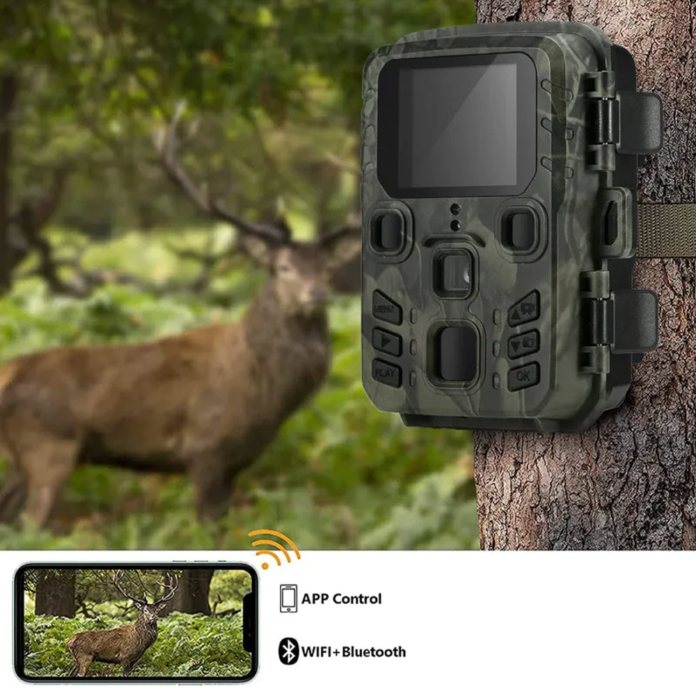 Camouflage TrackaPix Wildlife Camera on a tree with a deer in the background, featuring app control and connectivity options.