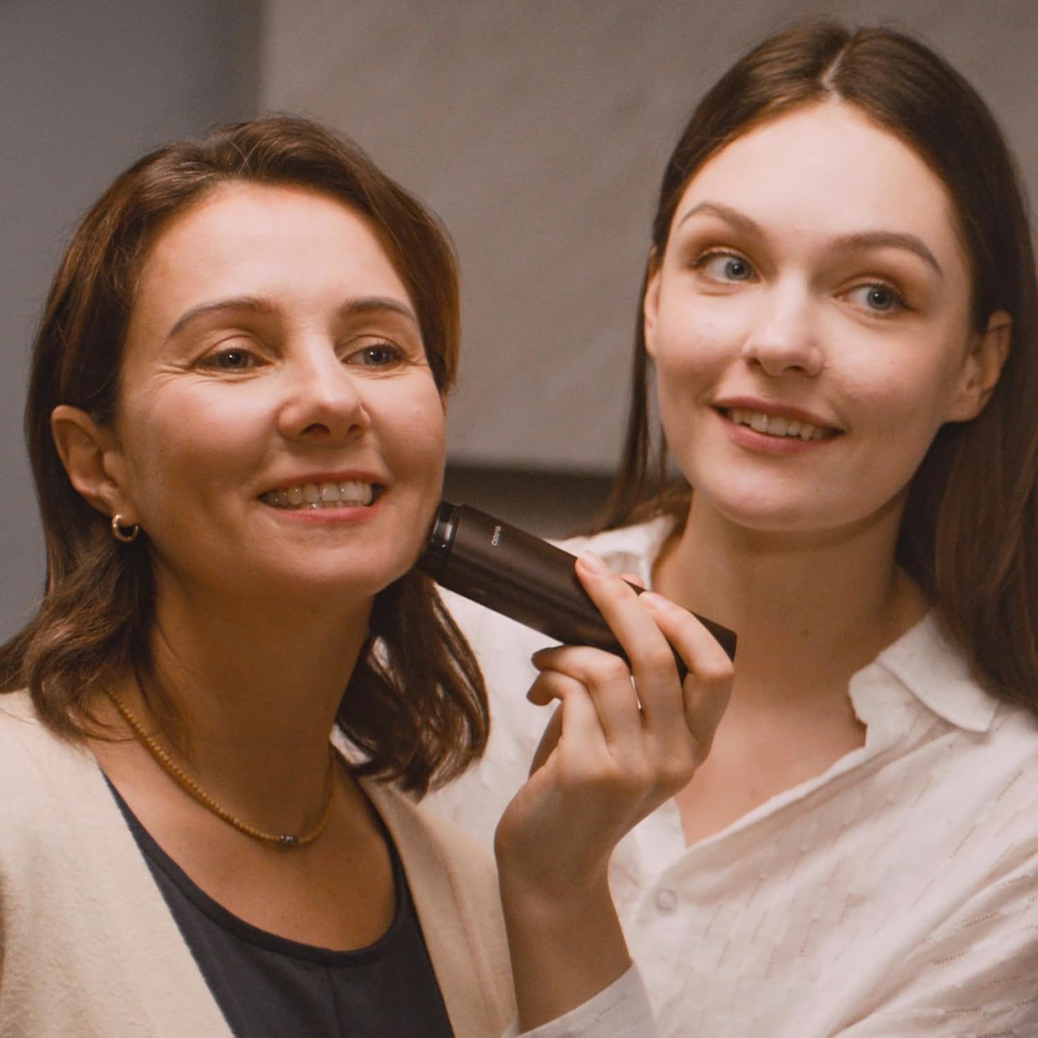 Two women smiling, one holding a Vellera S1 Pro Facial Skin Tightening Device