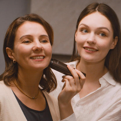 Two women smiling, one holding a Vellera S1 Pro Facial Skin Tightening Device