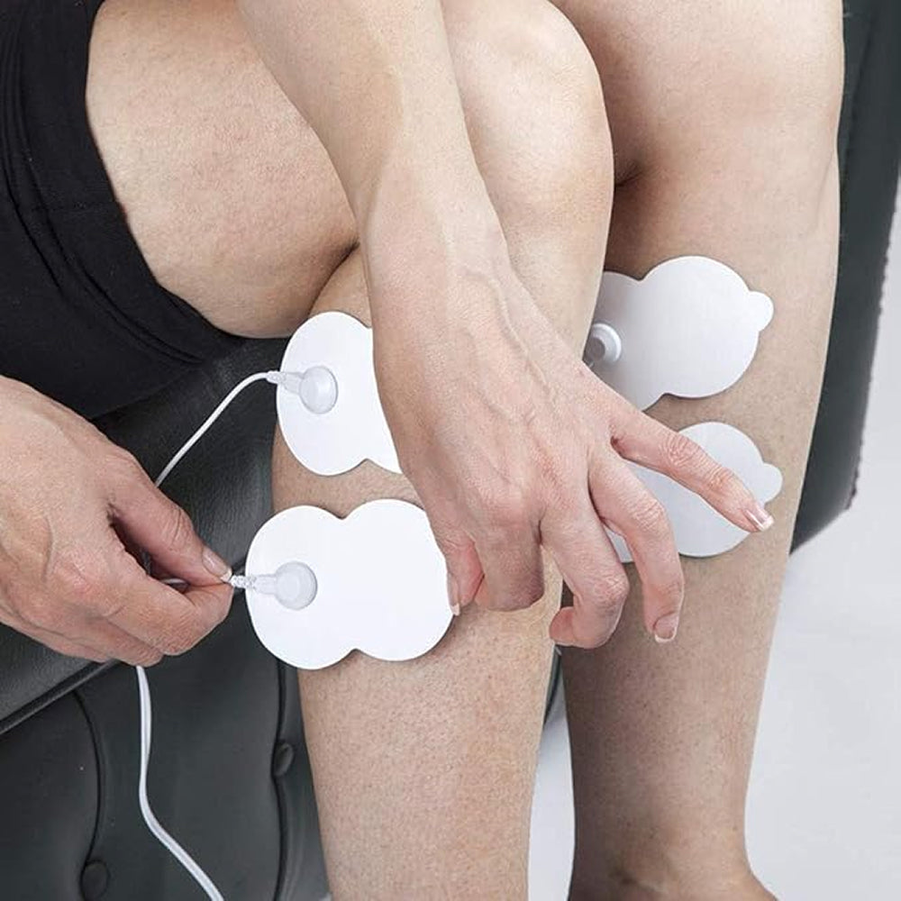 Person using electronic muscle stimulator pads on legs