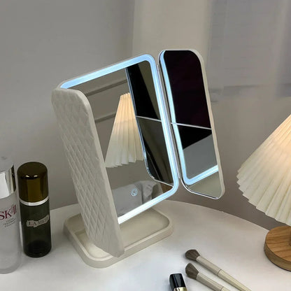 Double-sided vanity VeloGleam Lighted Makeup Mirror with LED lights on a white surface with skincare products.