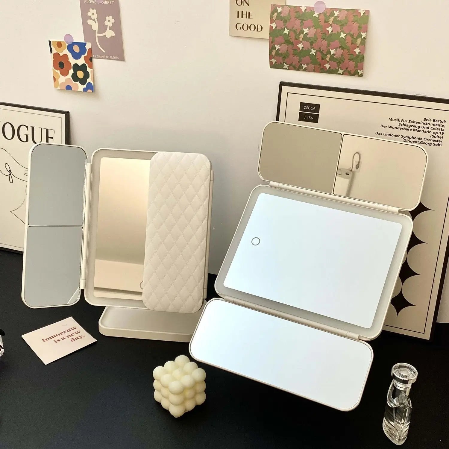 Foldable vanity VeloGleam Lighted Makeup Mirror with light on a table with decorative items.