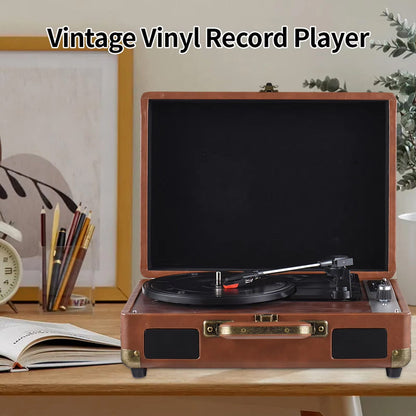 Vintage vinyl Vinixora Record Player on a desk with stationery items and a plant in the background.