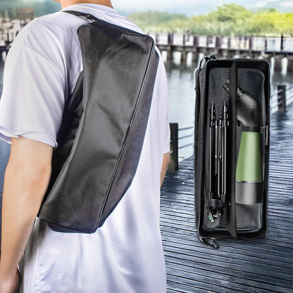 Person wearing a black crossbody bag with a green Virelta Spotting Scope and black umbrella on a dock.