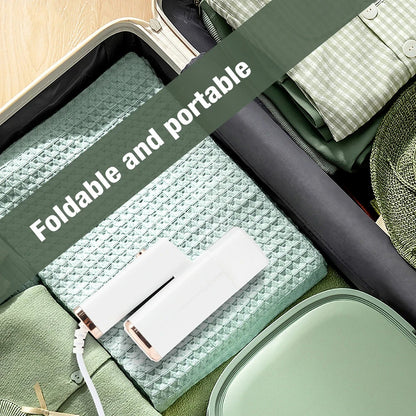 WandixStim Steamer with text 'Foldable and portable' on top of a suitcase with green and white items.