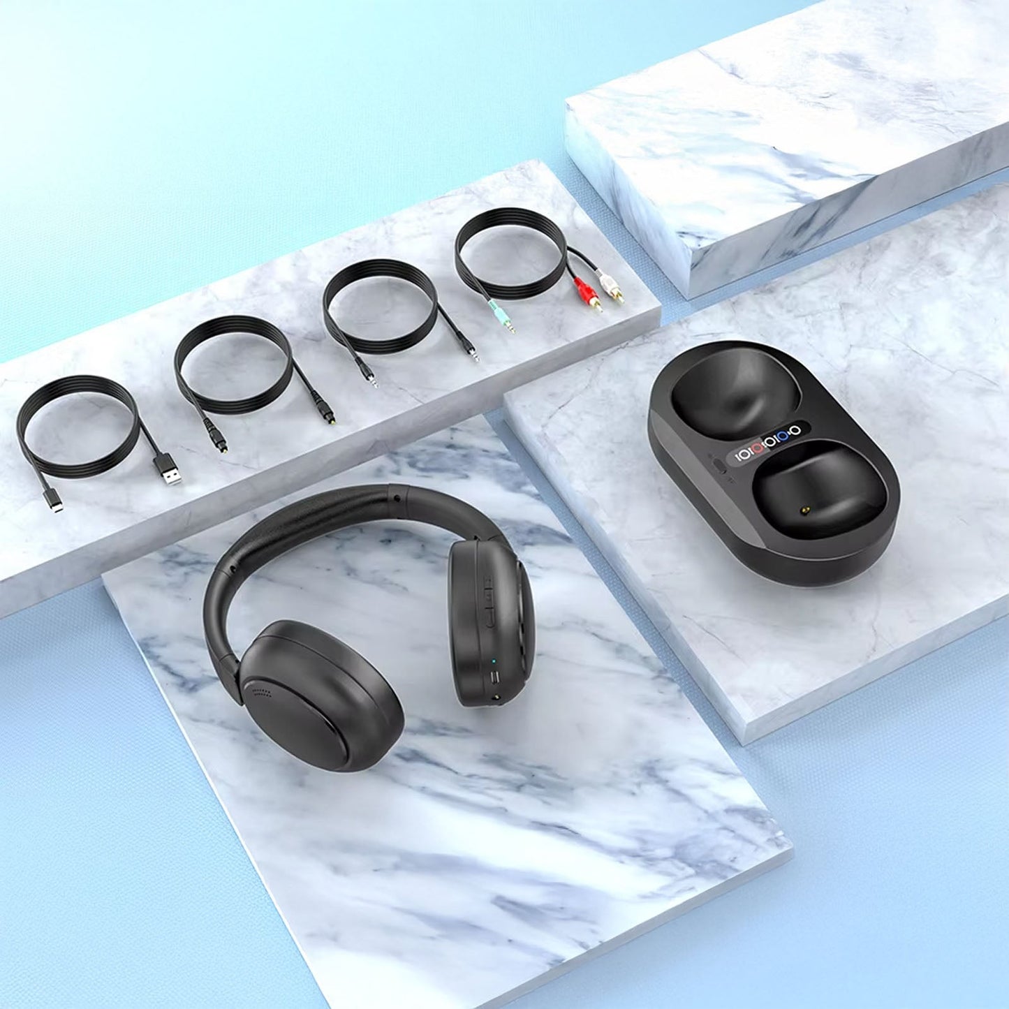 Black wireless Sintra TV Headphones and charging case on a marble surface with a blue background