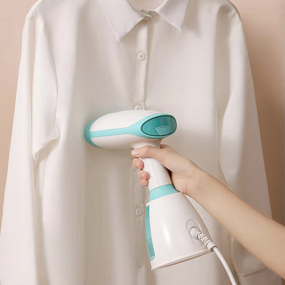 Hand using a white and CriisMist Handheld Steamer on a white shirt against a beige background