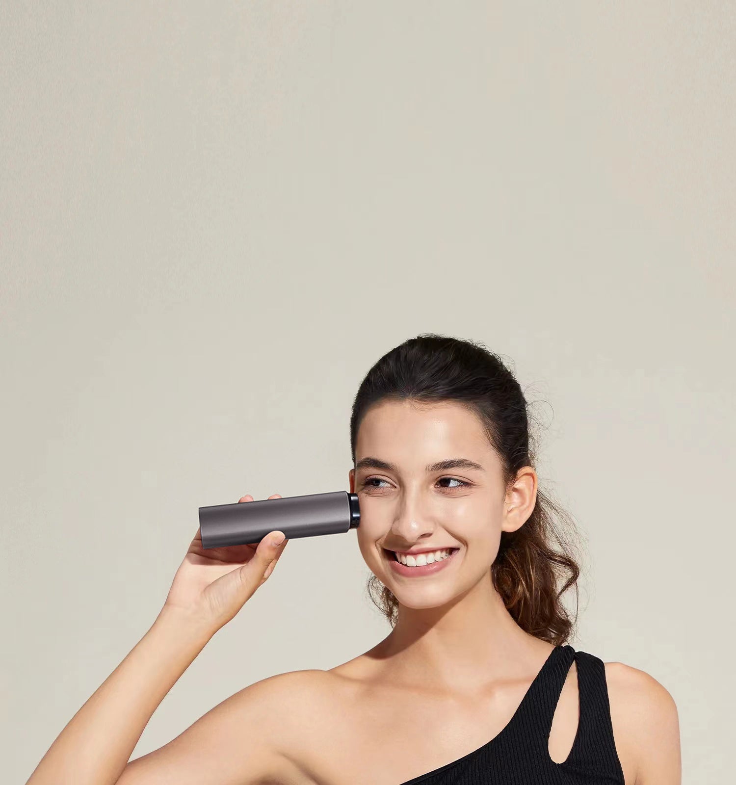 Woman holding a Vellera S1 Pro Facial Skin Tightening Device against a plain background
