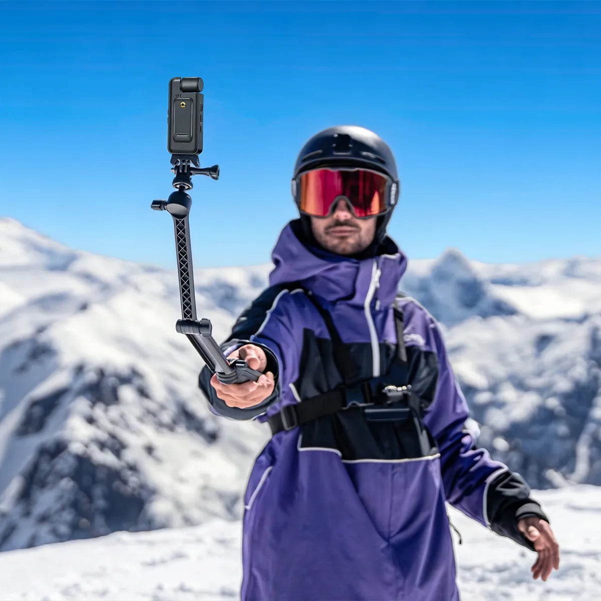 Person in ski gear holding a Geekik Mini Body Camera mount against a snowy mountain backdrop